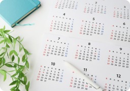 ペンと観葉植物が置かれた年間カレンダー