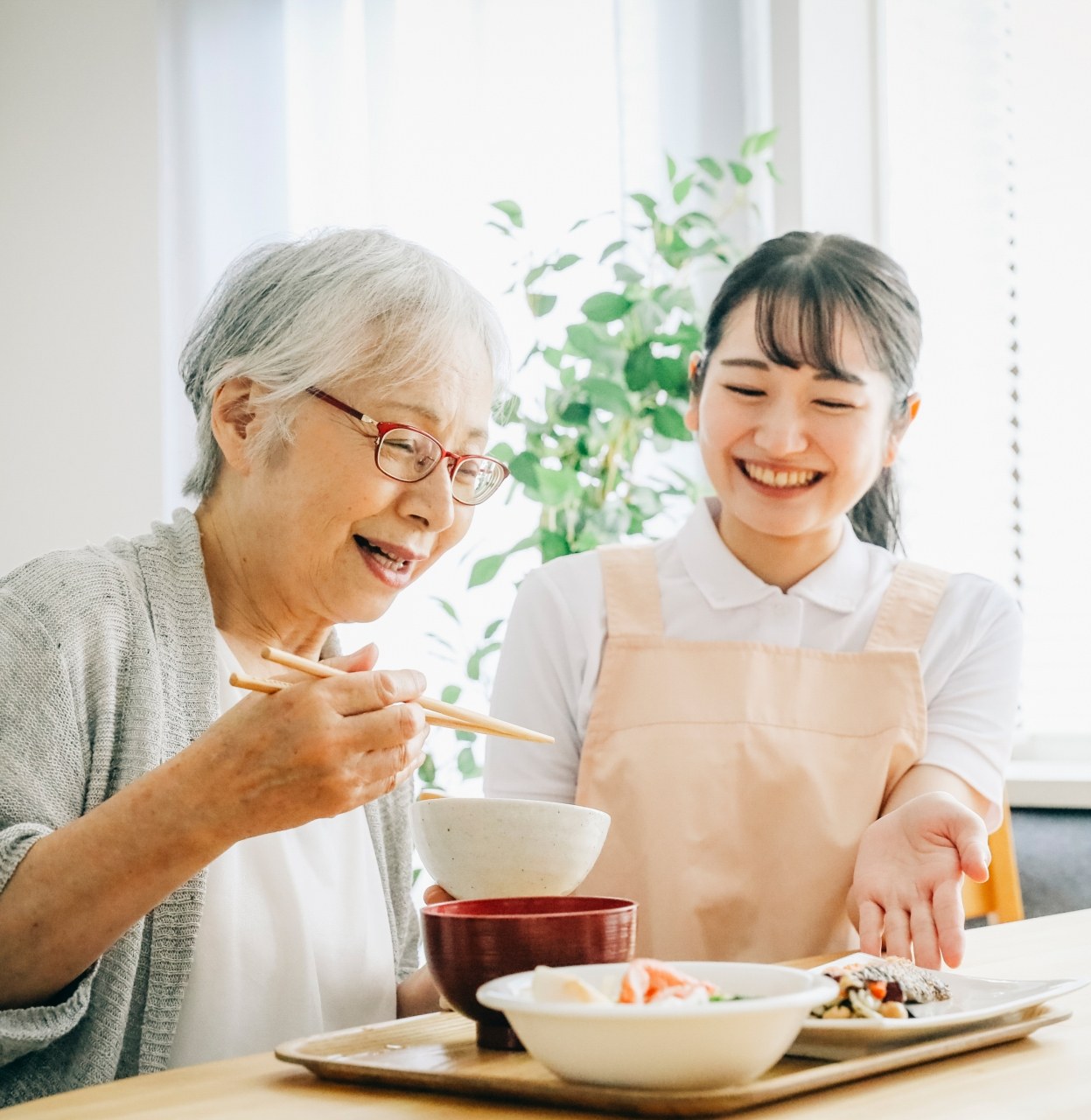 食事を前に笑顔で語らう高齢の女性たち